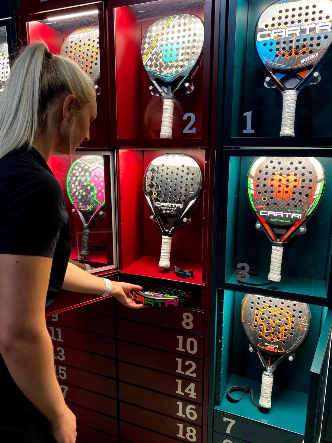 Tjej står framför en varuautomat med padelrackets för att testa